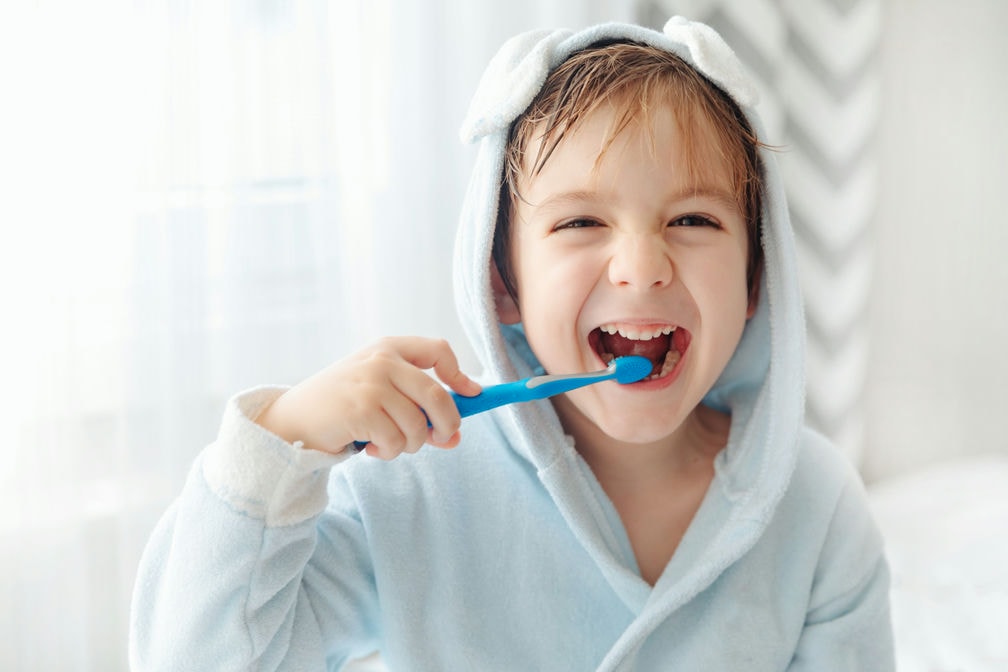 smiling happy child brushing teeth with toothbrush 2022 09 19 21 54 15 utc c