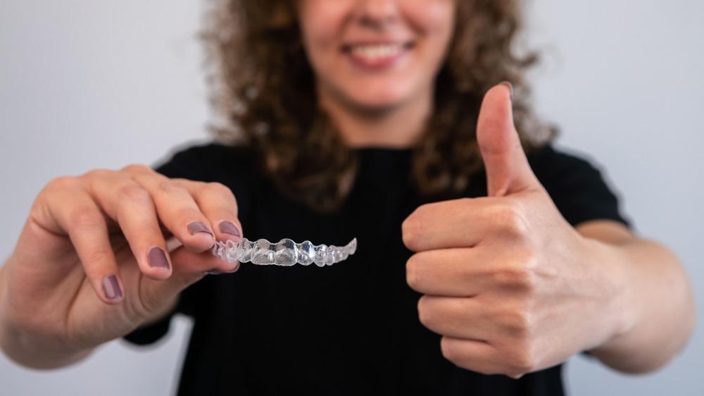 woman-holds-transparent-braces-for-dental-correcti-2022-10-05-17-35-49-utc (1)