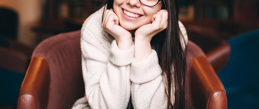 smiling-student-sitting-against-bookshelves-2022-11-03-04-25-20-utc (1)