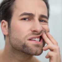 man-checking-his-teeth-and-looking-disturbed-2021-12-16-22-14-49-utc (1)