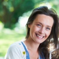 smiling-woman-sitting-outdoors-2022-03-04-01-52-53-utc (2) (1)