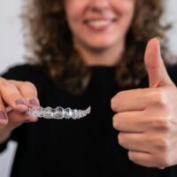 woman-holds-transparent-braces-for-dental-correcti-2022-10-05-17-35-49-utc (1)
